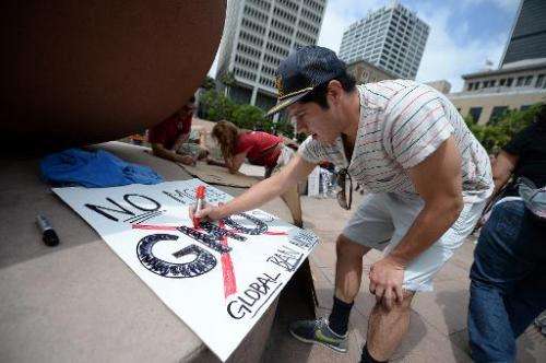 An activist makes a sign before a protest against chemical giant Monsanto, in Los Angeles, California, on May 25, 2013