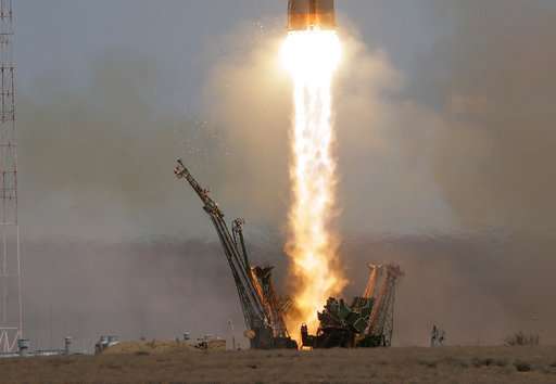 Soyuz space capsule carrying American, Russian blasts off