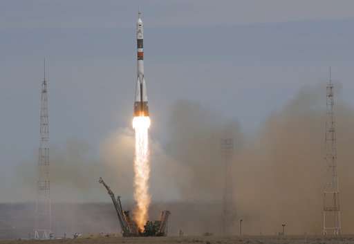 Soyuz space capsule carrying American, Russian blasts off