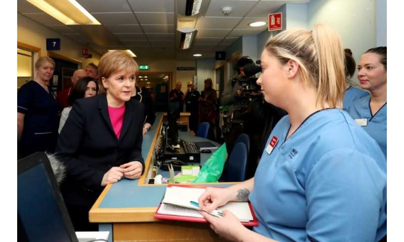 Sturgeon (L) meets clinicians during a visit to the Edinburgh Royal Infirmary as she marks the minimum unit pricing for alcohol 