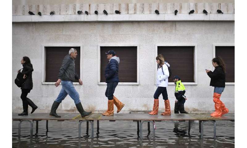 Officials erected a footbridge across a flooded street after the tide hit