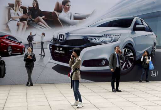 Electric car makers woo Chinese buyers with range, features