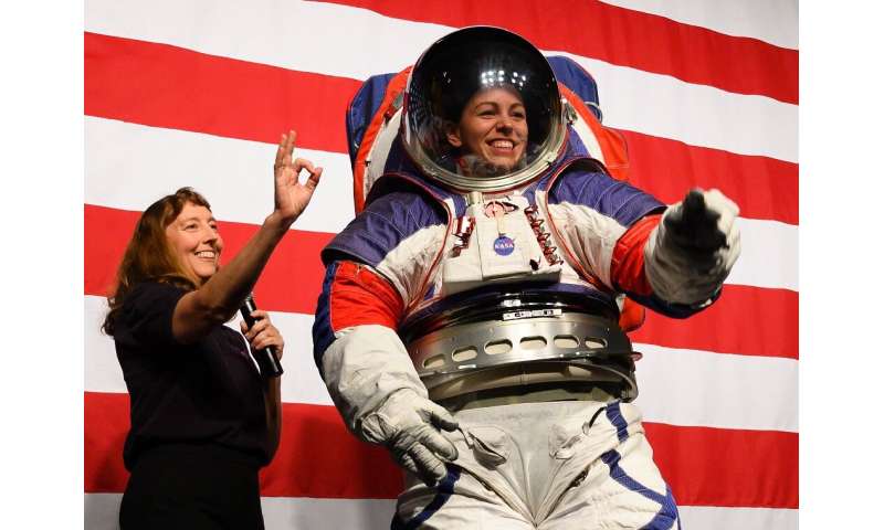 Advance space suit engineer, Kristine Davis (R), waves next to space suit engineer Amy Ross (L) during a press conference displa