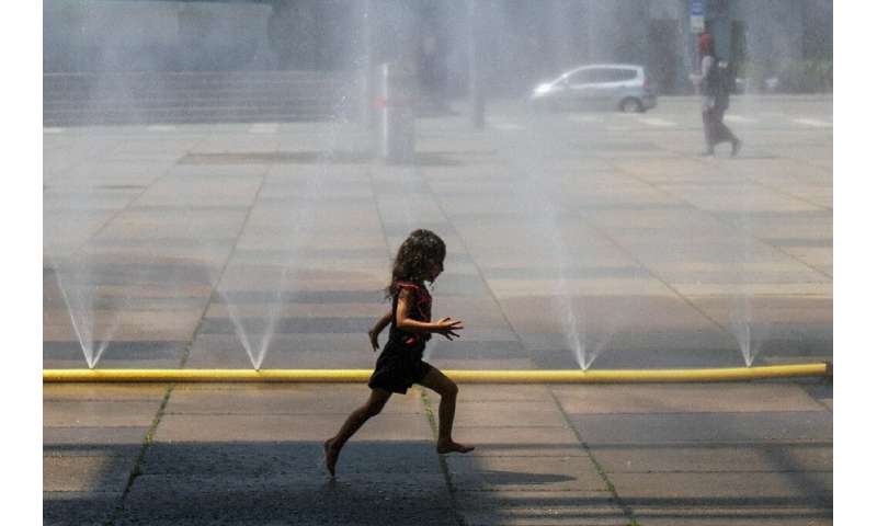 A girl runs through water at Praterstern Square in Vienna on July 25 amid a blistering heat wave
