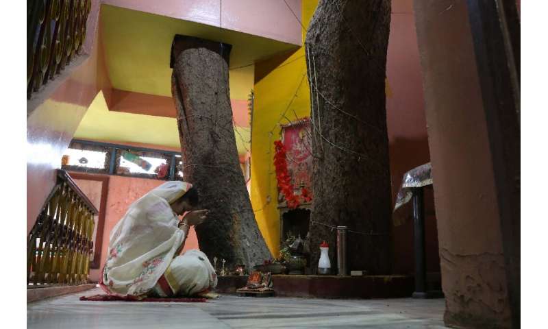Neelu Kesharwani, daughter-in-law of Moti Lal Kesharwani who built their house around a tree, performs a ritual on the second fl
