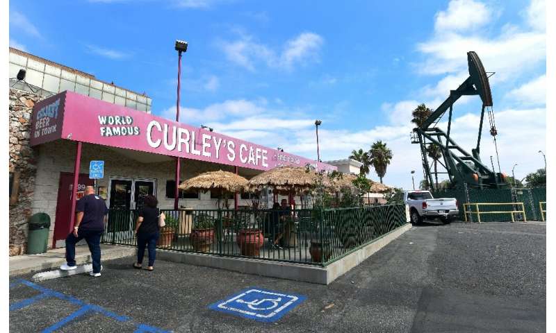 People make their way into Curley's Cafe in Signal Hill, which sits in the shadow of a pumpjack