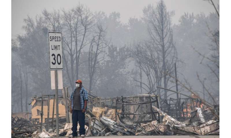 A man stands near some of the destruction caused by the Almeda Fire in Phoenix, Oregon, September 15, 2020