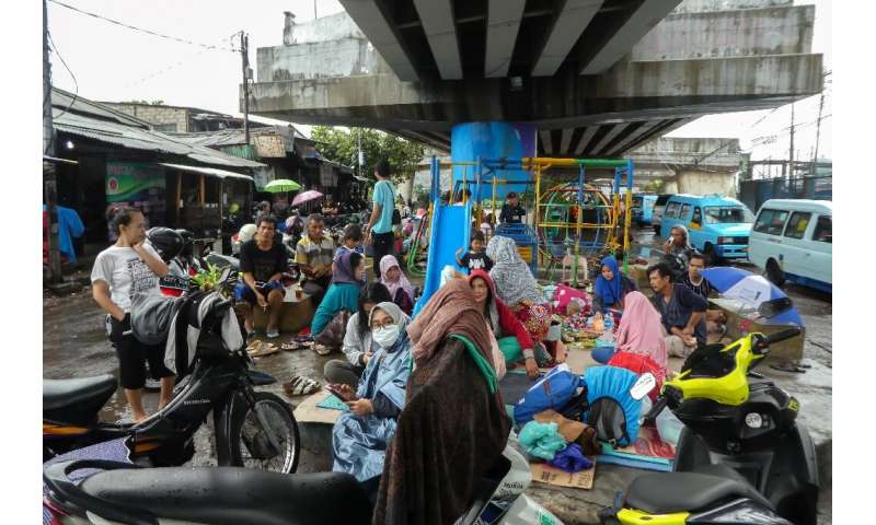Jakarta residents hit by flooding took shelter from heavy rain under flyovers