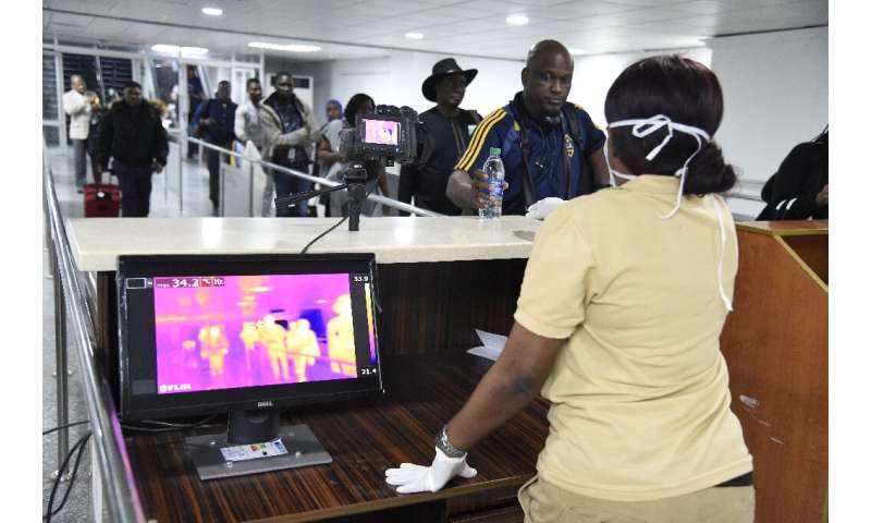 Passengers have their temperatures checked on arrival at the Murtala Mohammed International Airport in Lagos, Nigeria