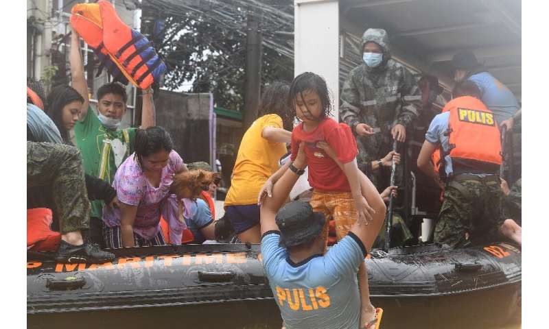 Rescuers evacuate residents from their flooded homes