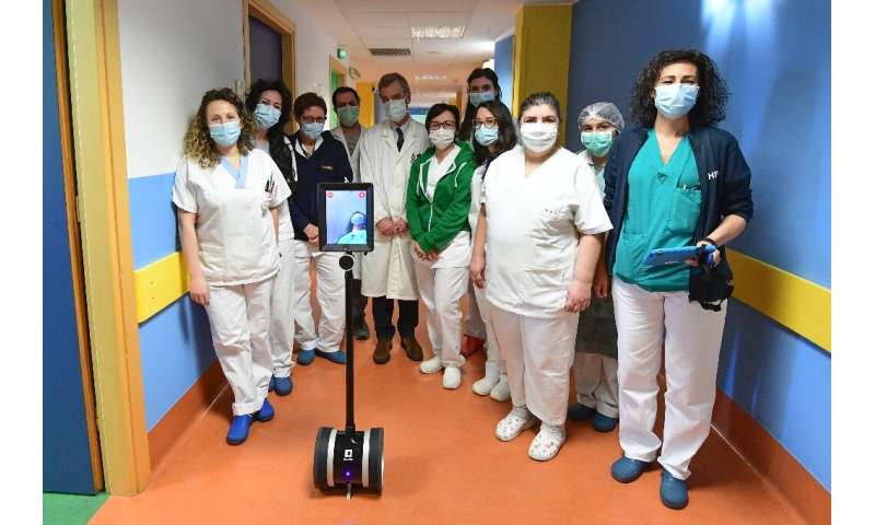 Medical staff in Varese, northern Italy, with Ivo the robot who helps them treat seriously ill coronavirus patients and reduce t