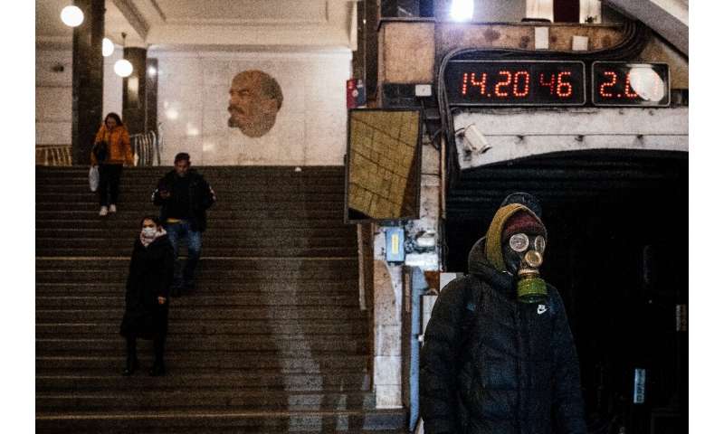 A man wearing a gas mask waits on the platform at the Biblioteka Imeni Lenina metro station in Moscow