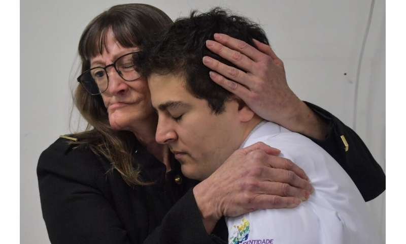 Denise Vicentin (L) embraces her doctor, Rodrigo Salazar, after receiving a digitally-engineered facial prosthesis