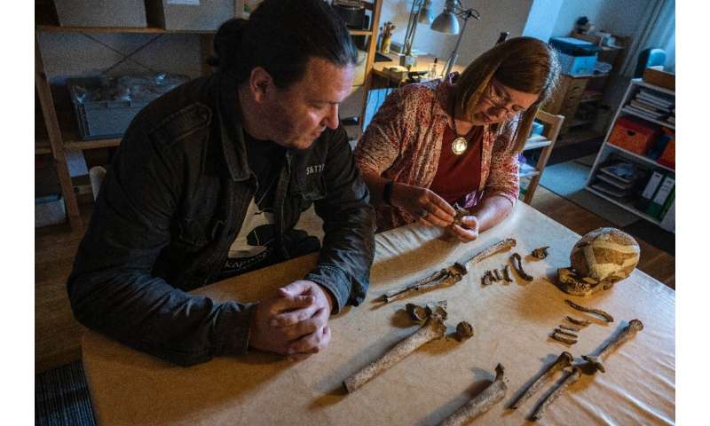 Archaeologist Philipp Roskoschinski (L) and anthropologist Bettina Jungklaus look at the skeletal remains of the so-called &quot