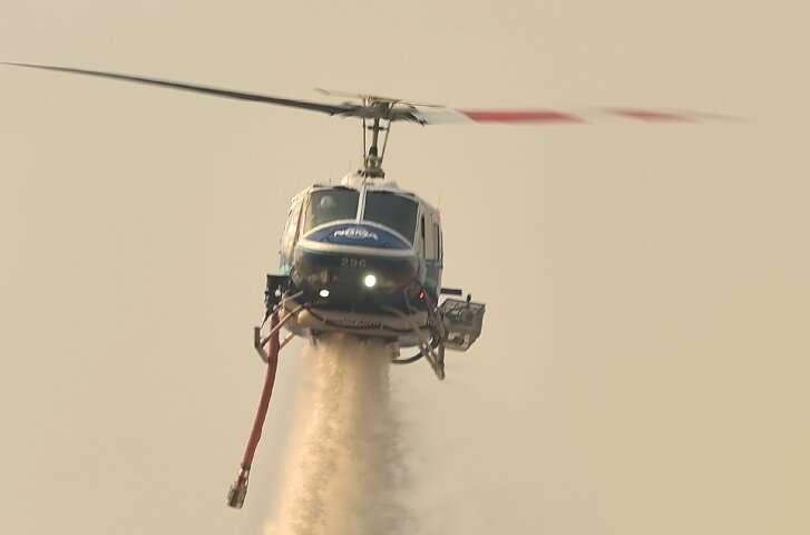 A helicopter drops water on a bushfire in Batemans Bay in New South Wales