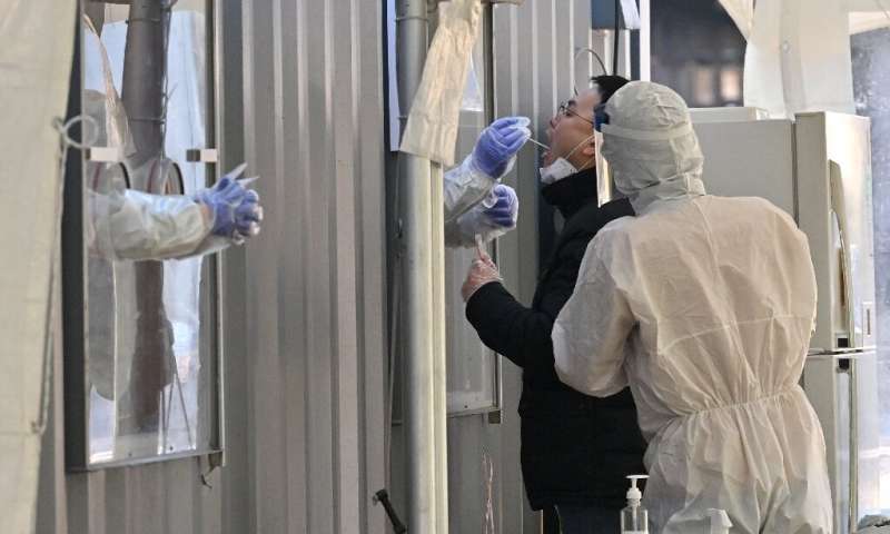 一个男人在首尔的测试设施中为冠状病毒擦拭
