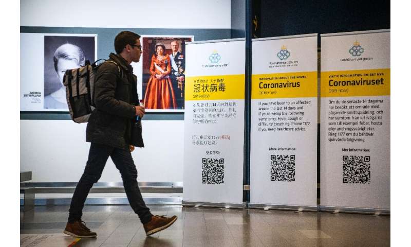 A passenger arriving in Stockholm's Arlanda airport is greeted by signs produced by the public health agency advising travelers 