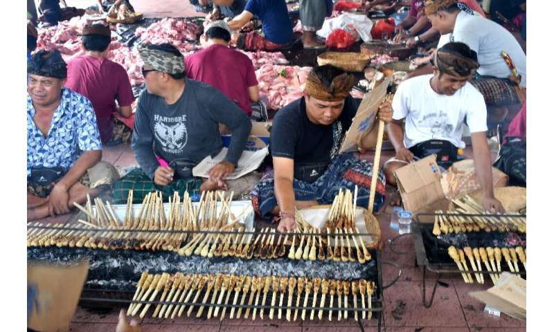 Balinese men preparing pork sate for a traditional wedding on Indonesia's resort island of Bali. Hundreds of pigs have died from