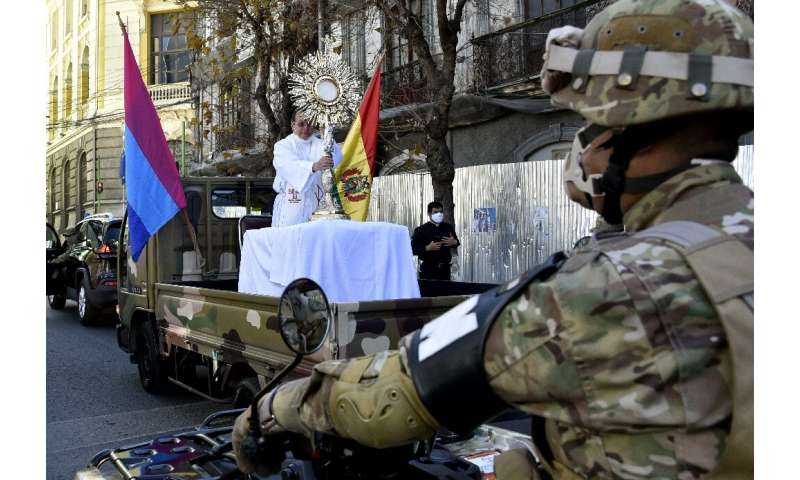 Bolivian soldiers escort a Corpus Christi procession heading to the cathedral, in La Paz, amid the COVID-19 pandemic