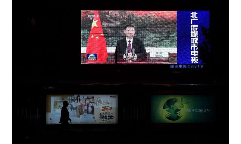 Chinese President Xi Jinping appears on an outdoor screen in Beijing as he speaks by video link at the United Nations General As
