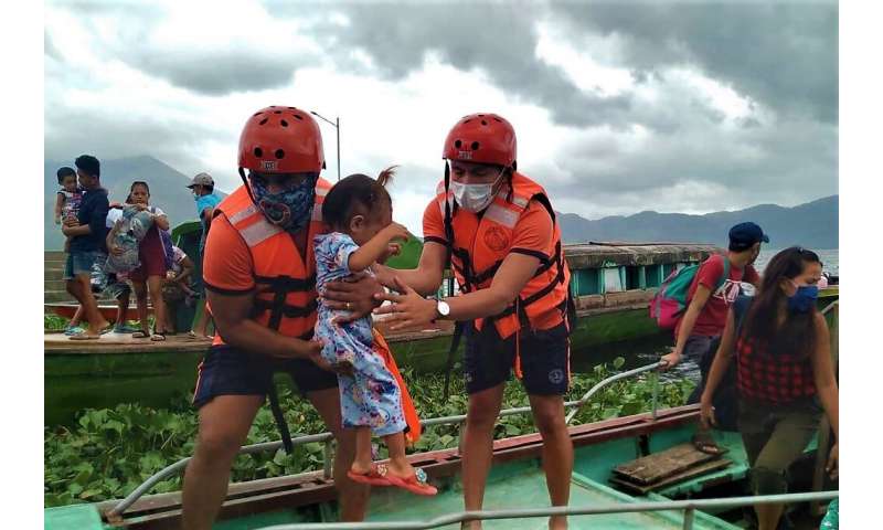 Coastguard workers evacuate residents from the coastal villages of Buhi town, Camarines Sur province, south of Manila