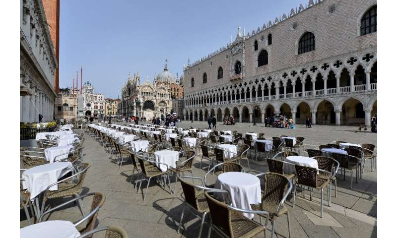 Deserted tables in front of the Doge palace in Venice, Italy
