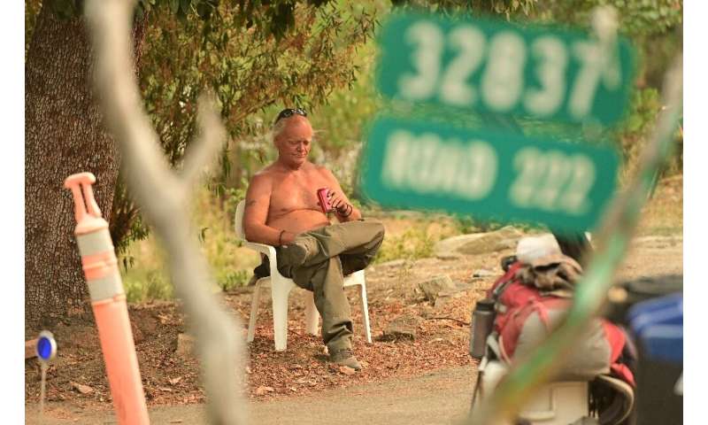 Evacuee Clay Brazil waits to be picked up during the Creek Fire in the North Fork area of unincorporated Madera County, Californ
