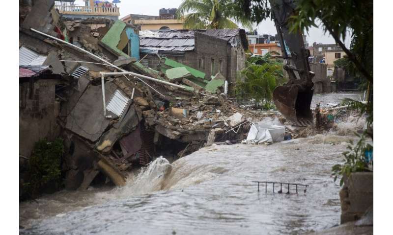 Houses collapsed after floodwaters ran through the streets of Santo Domingo as Tropical Storm Laura batters the region