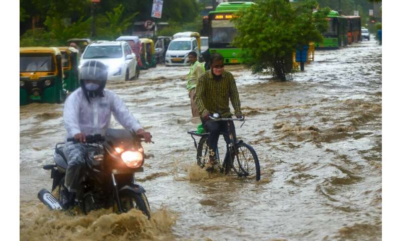 In New Delhi, commuters battled through knee-deep waters