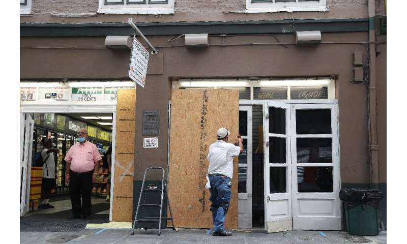 Luis Sanabria puts plywood over the windows of a business in the historic French Quarter before the possible arrival of Hurrican