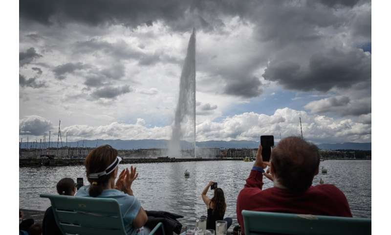 People applaud during a ceremony marking the restarting of Geneva's landmark fountain, known as &quot;Jet d'Eau&quot;, which was