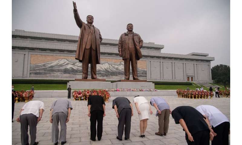 People bow as they pay their respects before the statues of late North Korean leaders Kim Il Sung and Kim Jong Il as the country
