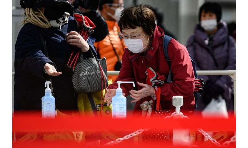 People clean their hands with hand sanitiser in Fukushima, Japan