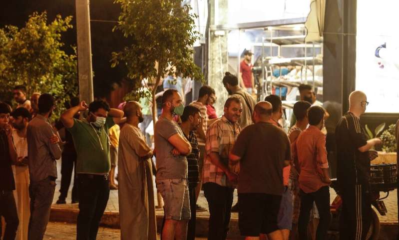 People queue at a bakery in Gaza City after new lockdowns were announced across the city due to cases of the novel coronavirus l