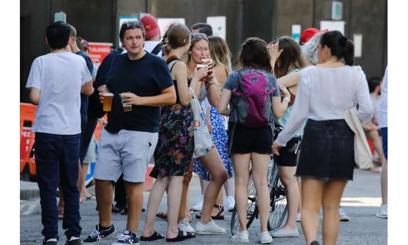 People relax with takeaway beer in plastic cups—and not much social distancing—at Borough Market in London