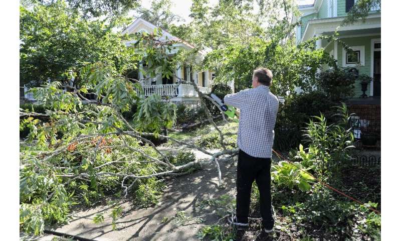 Residents of Wilmington clean up tree branch debris after Hurricane Isaias made landfall near the town in North Carolina