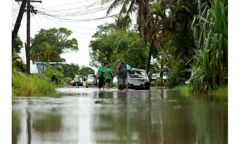 Residents wade through the flooded streets in Fiji's capital city of Suva on December 16, 2020, ahead of super cyclone Yasa