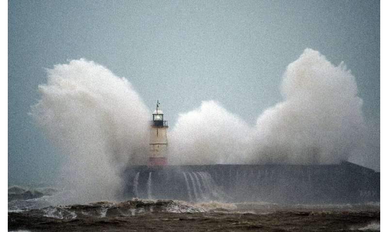 Waves crash over Newhaven Lighthouse on the south coast of England