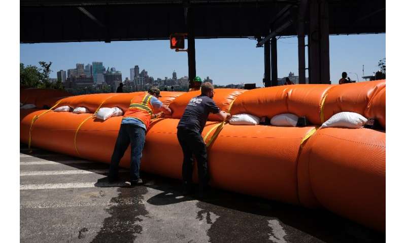 Workers erect temporary flood barriers in the South Street Seaport neighborhood in New York City