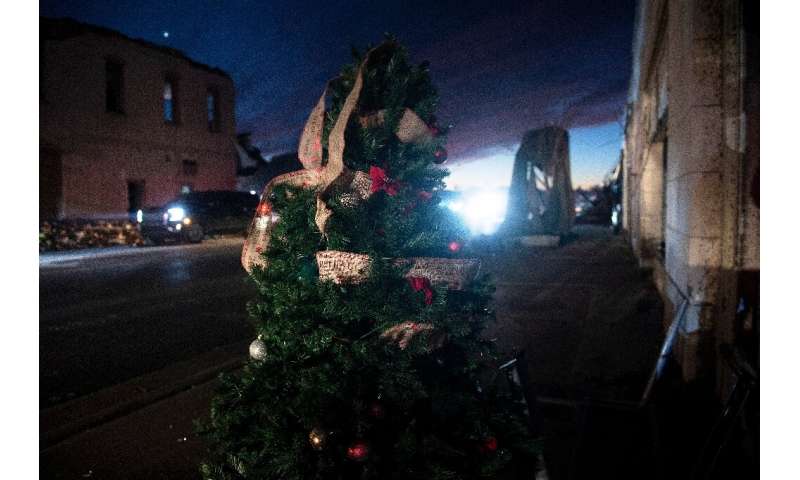 A Christmas tree stands by a road amid the damage in Mayfield