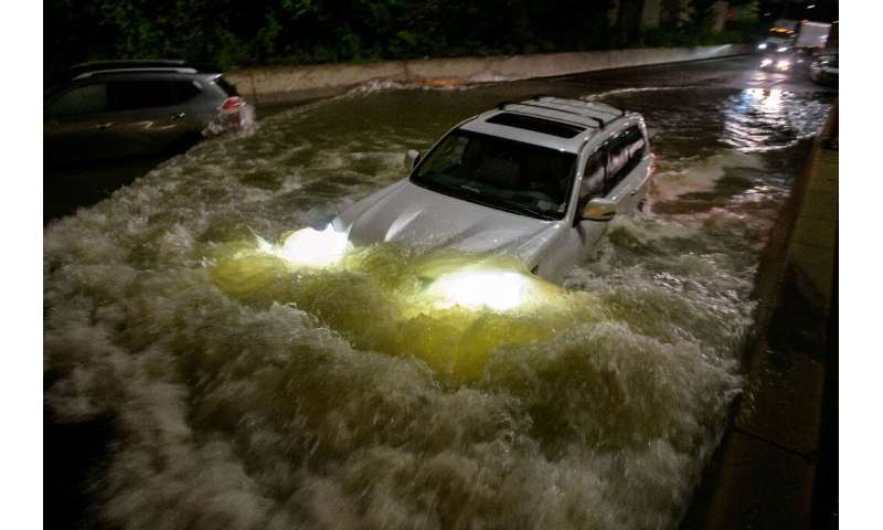 A motorist drives a car through a flooded expressway in Brooklyn, New York early on September 2, 2021, as flash flooding and rec