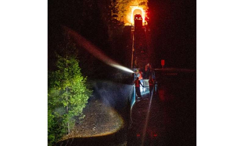 Along steep slopes firefighters have used a train to spray the blaze