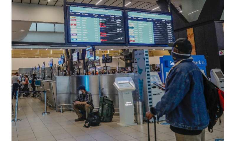 Anxious travelers rush to Johannesburg International Airport,