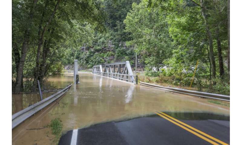 A bridge and a road are submerged by floodwaters from the North Fork of the Kentucky River in Jackson, Kentucky