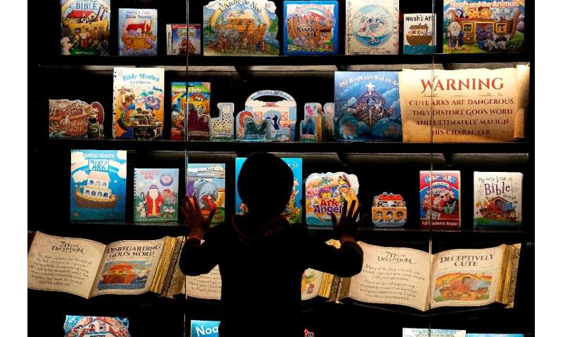 A child looks at a display showing depictions of Noah’s Ark stories