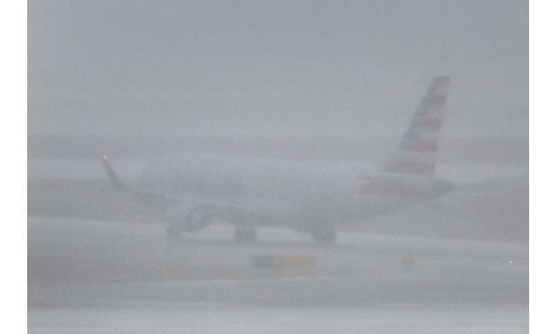 A jet plane takes off at O'Hare International Airport in Chicago, Illinois during a massive winter storm that brings snow, high winds, a