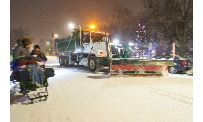 Снегоочиститель расчищает дорогу 23 декабря 2022 года в Лондоне, Онтарио, Канада, во время сильного зимнего шторма, обрушившегося на Северную Америку.