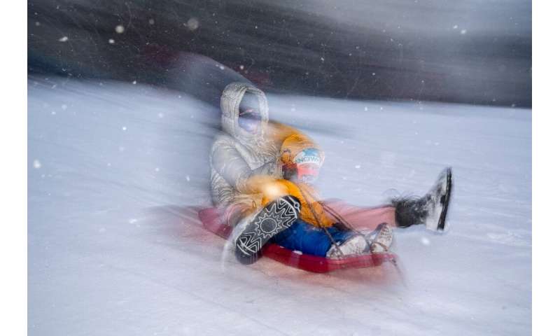 کودکان در هنگام طوفان برفی در واشنگتن در کاپیتول هیل اسکیت می کنند
