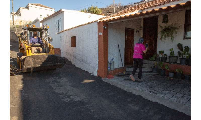 Gladys Jeronimo, 65, cleans sand and ash from her home in the Las Manchas neighbourhood after the Cumbre Vieja volcano's eruptio