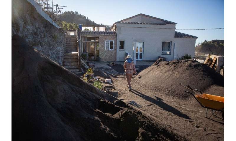 Maria Zobeida Perez Cabrera, 68, removes ash from her garden in the Las Manchas neighborhood of La Palma